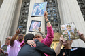 Lori Schott, center, is embraced as she holds up a photo of her daughter Annalee Schott, after the verdict in a landmark trial over whether social media platforms deliberately addict and harm children at Los Angeles Superior Court, Wednesday, March 25, 2026, in Los Angeles. (AP Photo/William Liang)