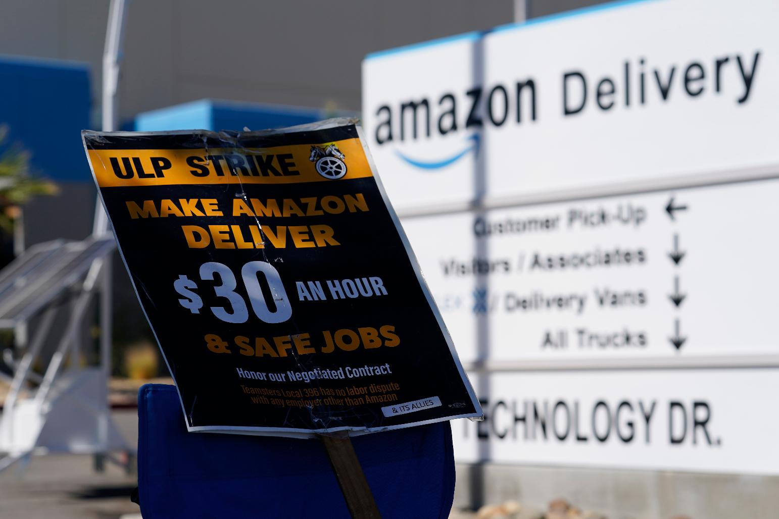 A sign rests on a chair as workers who unionized with the Teamsters picket outside one of the Amazon's distribution centers on Monday, July 24, 2023, in Palmdale, Calif. Dozens of Amazon drivers and dispatchers who work for a California-based delivery firm the Teamsters unionized in April have been picketing company warehouses, calling on the e-commerce behemoth to come to the table and bargain over pay and working conditions. (AP Photo/Marcio Jose Sanchez)