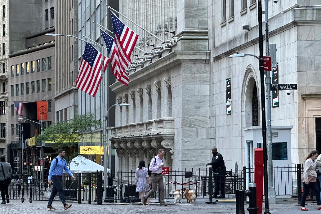 FILE - People pass the New York Stock Exchange on Wednesday, May 29, 2024, in New York. Some U.S. companies saw the trading of their shares temporarily halted Monday, June 3, including at least one whose price briefly fell nearly 100%, following a technical issue for some stocks listed on the New York Stock Exchange. (AP Photo/Peter Morgan, File)