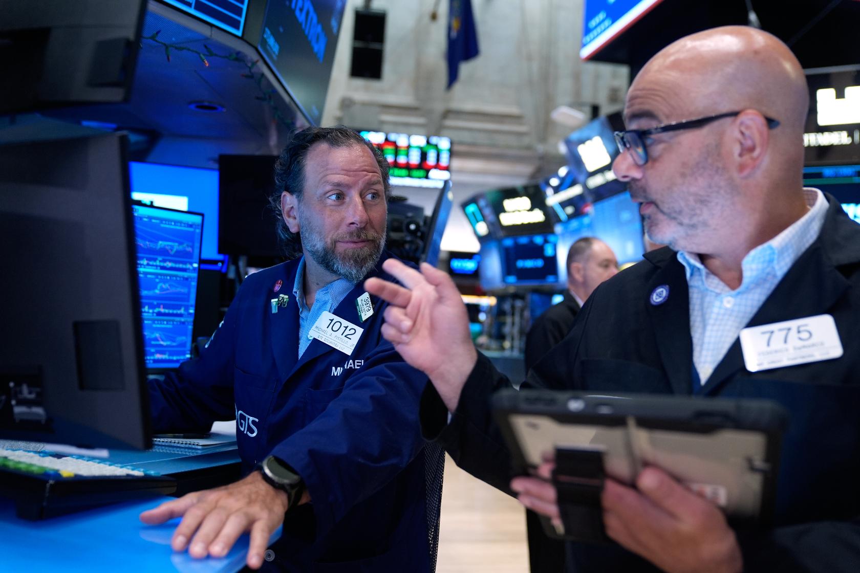 Michael Pistillo, left, and Federico DeMarco work on the floor at the New York Stock Exchange in New York, Monday, July 6, 2026. (AP Photo/Seth Wenig)