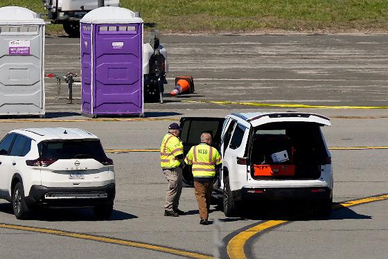 NTSB officials arrive to inspect the wreckage of an Air Canada Express jet, Tuesday, March 24, 2026, just off the runway where it had collided with a Port Authority fire truck Sunday night at LaGuardia Airport in New York. (AP Photo/Yuki Iwamura)