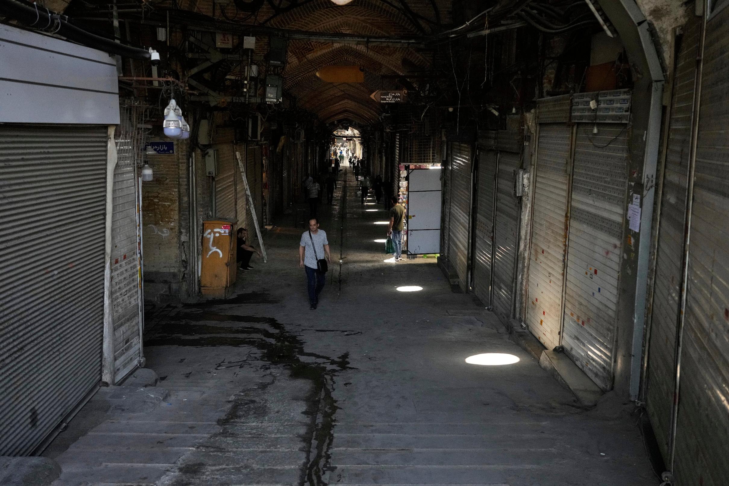 FILE.- Few pedestrians walk along the historic Grand Bazaar as most shops remain shuttered, in Tehran, Iran, Monday, June 16, 2025. (AP Photo/Vahid Salemi, File