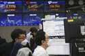 Currency traders watch monitors at the foreign exchange dealing room of the KEB Hana Bank headquarters in Seoul, South Korea, Friday, April 30, 2021. Asian shares were mostly lower Friday amid uncertainty about the prospects for a gradual global economic recovery from the coronavirus pandemic. (AP Photo/Ahn Young-joon)