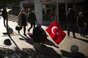 A man sells Turkish flags in a commercial area in Kadikoy neighbourhood in Istanbul, Turkey, Thursday, Dec. 2, 2021. Turkey’s beleaguered currency has been plunging to all-time lows against the U.S. dollar and the euro in recent months as President Recep Tayyip Erdogan presses ahead with a widely criticized effort to cut interest rates despite surging consumer prices. (AP Photo/Francisco Seco)