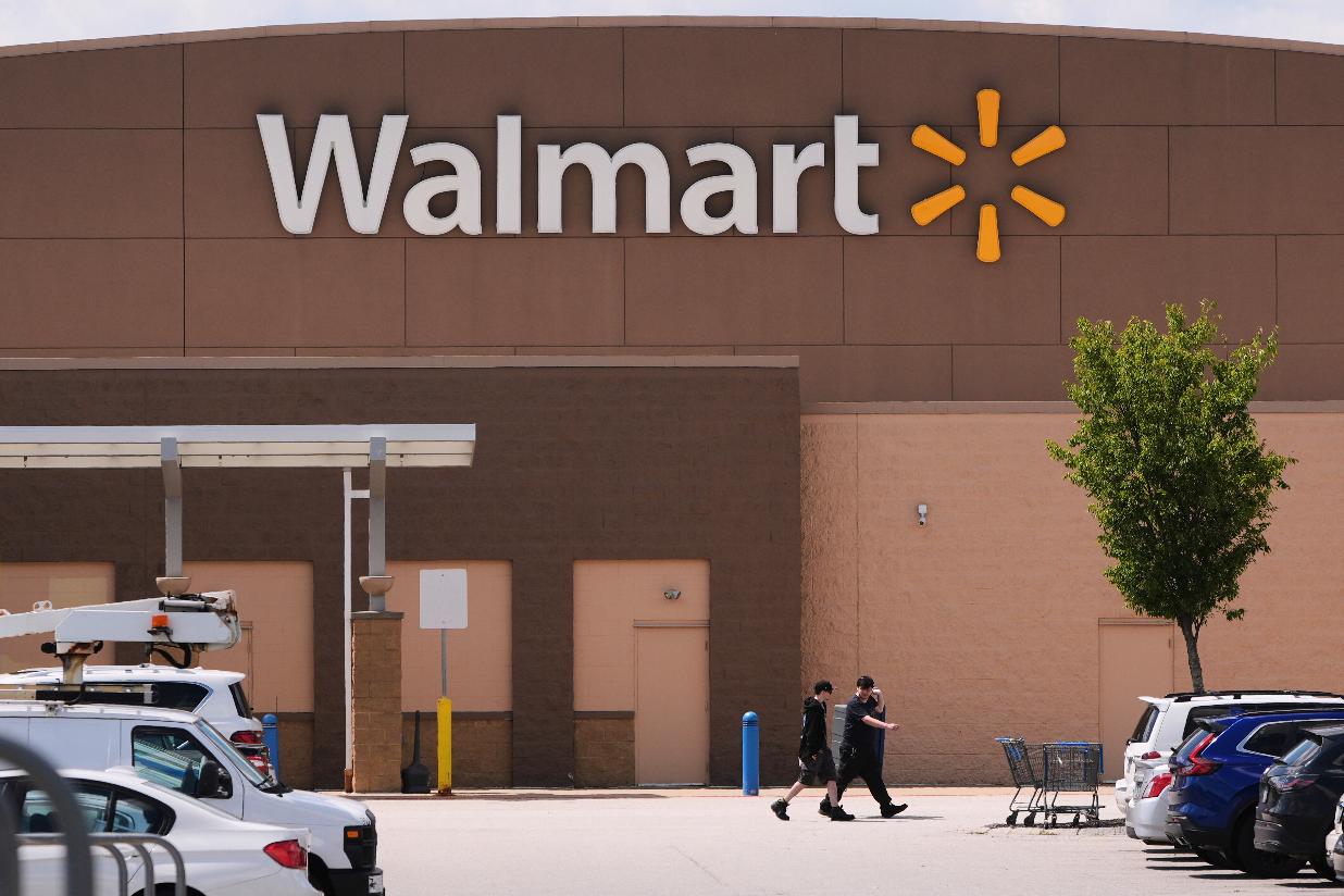 FILE - Shoppers walk from the Walmart store, Aug. 14, 2025, in Manchester, N.H. (AP Photo/Charles Krupa, file)