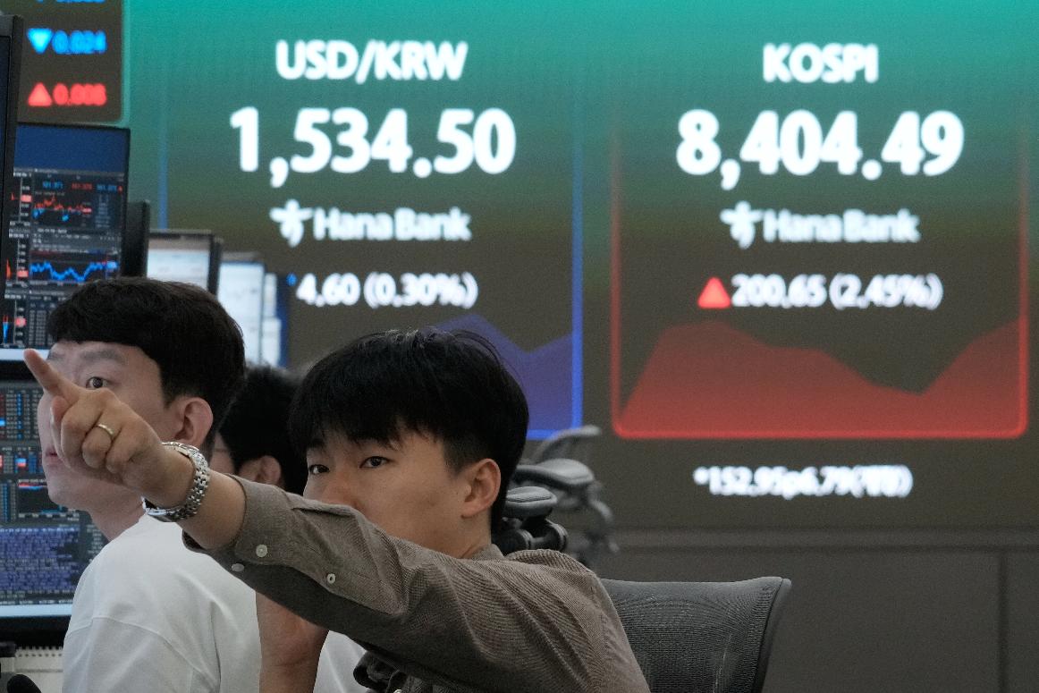 A currency trader watches monitors near a screen showing the Korea Composite Stock Price Index (KOSPI) and the foreign exchange rate between U.S. dollar and South Korean won at the foreign exchange dealing room of the Hana Bank headquarters in Seoul, South Korea, Wednesday, June 24, 2026. (AP Photo/Ahn Young-joon)