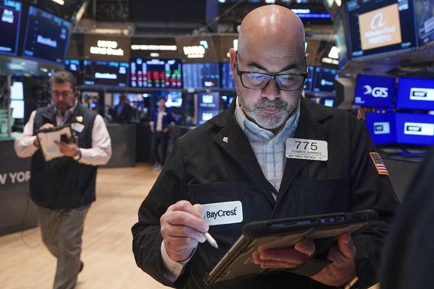 Trader Fred Demarco, right, works on the floor of the New York Stock Exchange, Friday, Feb. 13, 2026, in New York. (AP Photo/Richard Drew)
