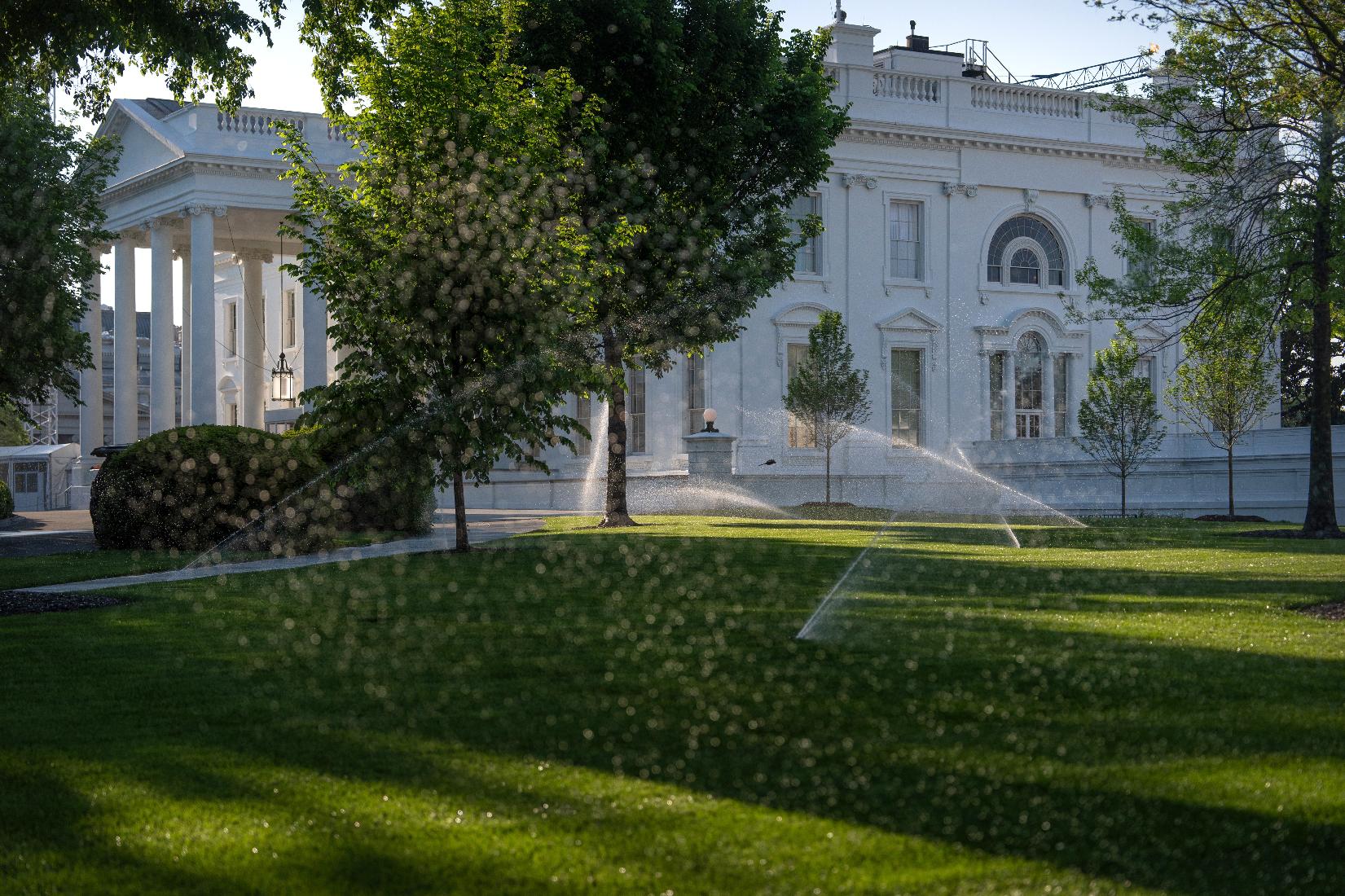Sprinklers water the North Lawn of the White House, Thursday, April 23, 2026, in Washington. (AP Photo/Mark Schiefelbein)