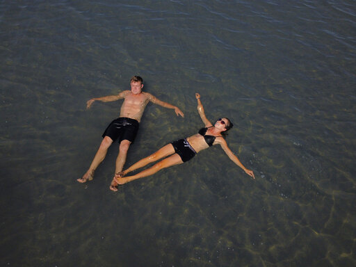 Great Salt Lake visitors Benny and Faith Martens float on the water at the Great Salt Lake Tuesday, Sept. 6, 2022, near Salt Lake City. A blistering heat wave is breaking records in Utah, where temperatures hit 105 degrees Fahrenheit (40.5 degrees Celsius) on Tuesday, making it the hottest September day recorded going back to 1874. (AP Photo/Rick Bowmer)