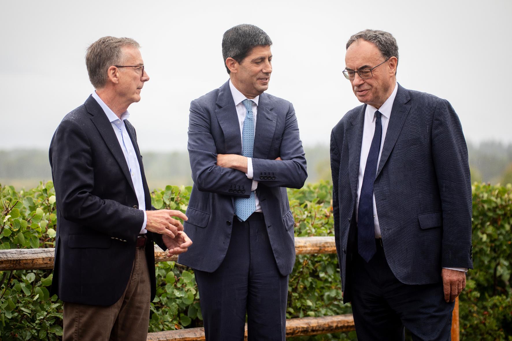Fed Chair Kevin Warsh, center, talks to Bank of England Governor Andrew Bailey, right, and Bank of Canada Governor Tiff Macklem at the annual Jackson Hole Economic Policy Symposium on Friday, Aug. 28, 2026, in Moran, Wyo. (AP Photo/Amber Baesler)
