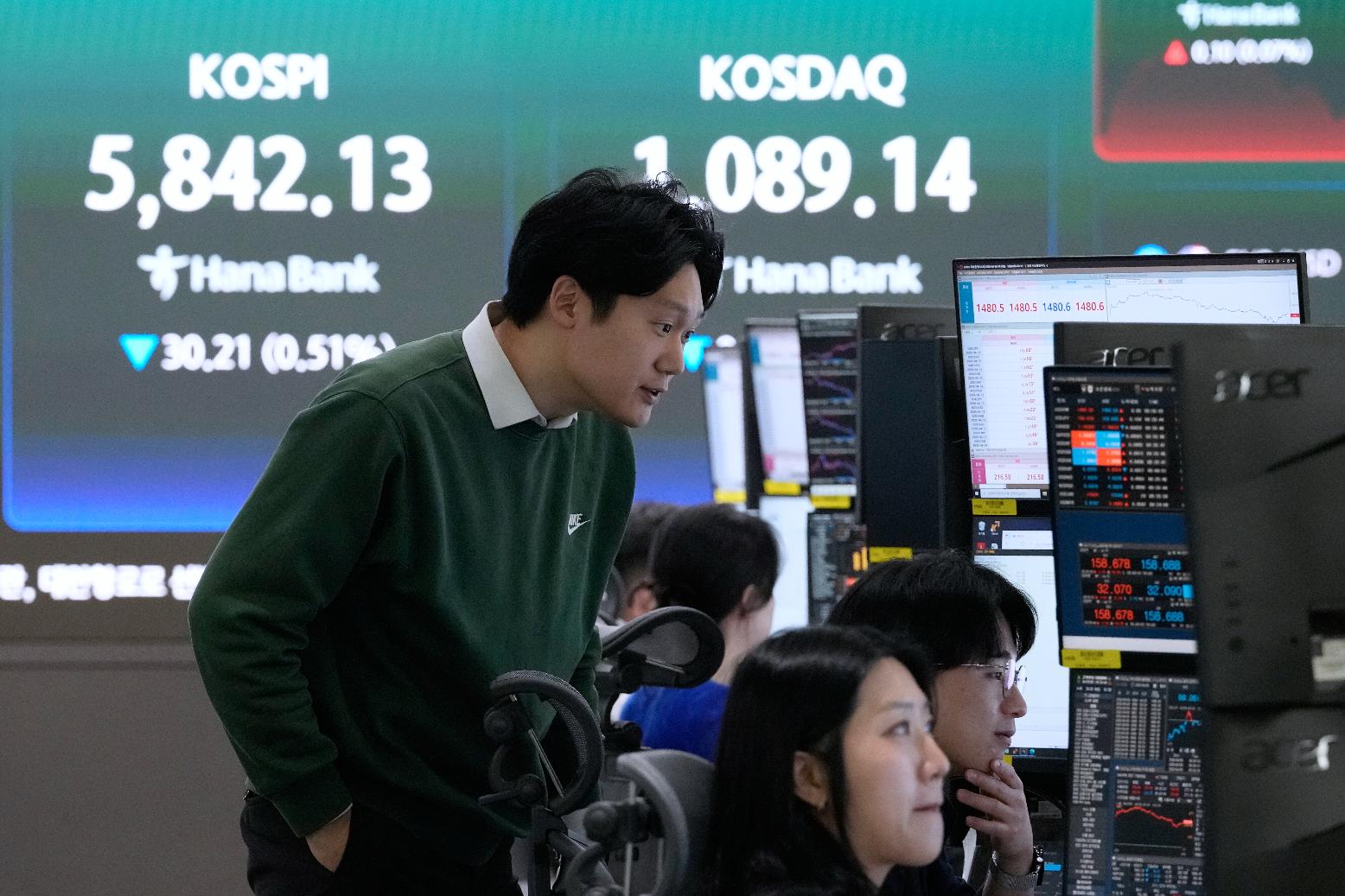 Currency traders watch monitors near a screen showing the Korea Composite Stock Price Index (KOSPI), top left, at the foreign exchange dealing room of the Hana Bank headquarters in Seoul, South Korea, Thursday, April 9, 2026. (AP Photo/Ahn Young-joon)
