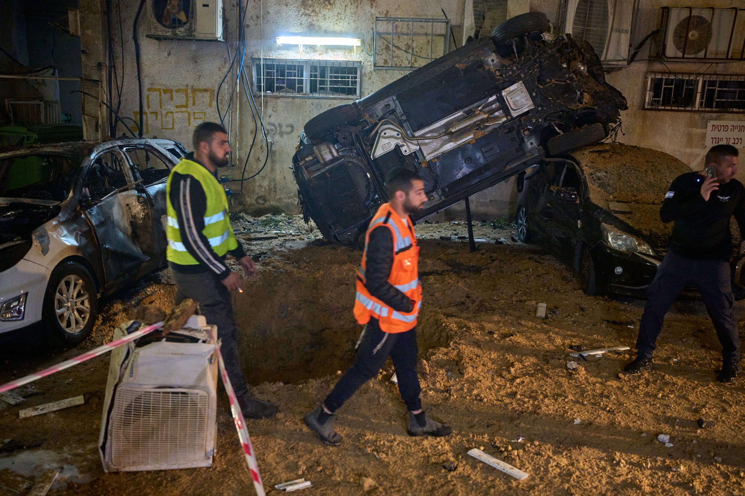 Israeli security forces inspect damage at the site of an Iranian missile strike in Holon, central Israel, Sunday, March 15, 2026. (AP Photo/Ohad Zwigenberg)