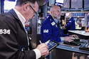 Trader Edward Curran, left, and specialist Meric Greenbaum, center, work on the floor of the New York Stock Exchange, Friday, May 22, 2026. (AP Photo/Richard Drew)