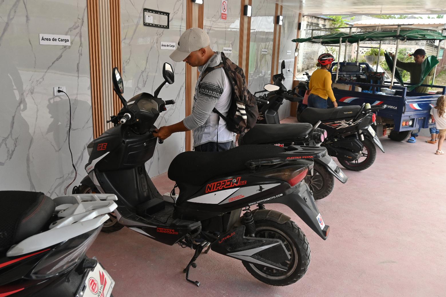 Giraldo Lazaro Perez Paret, who works in the tourism sector, recharges his electric motorcycle in Santa Clara, Cuba, Saturday, May 2, 2026. (AP Photo/Jorge Luis Banos)