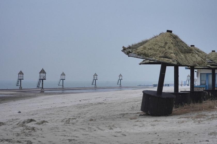 Watchtowers stand at an empty beach at the semi-abandoned "Life in Venice" housing complex in Qidong, on China's east coast, Feb. 5, 2026. (AP Photo/Dake Kang)