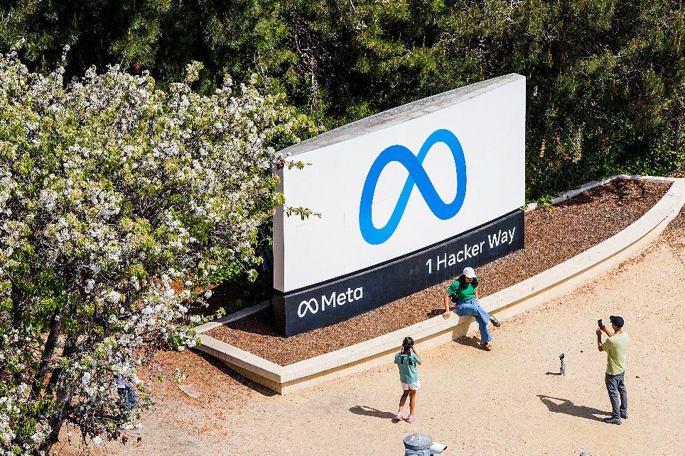 FILE - Visitors take photos at a sign outside Meta headquarters March 26, 2026, in Menlo Park, Calif. (AP Photo/Noah Berger, File)