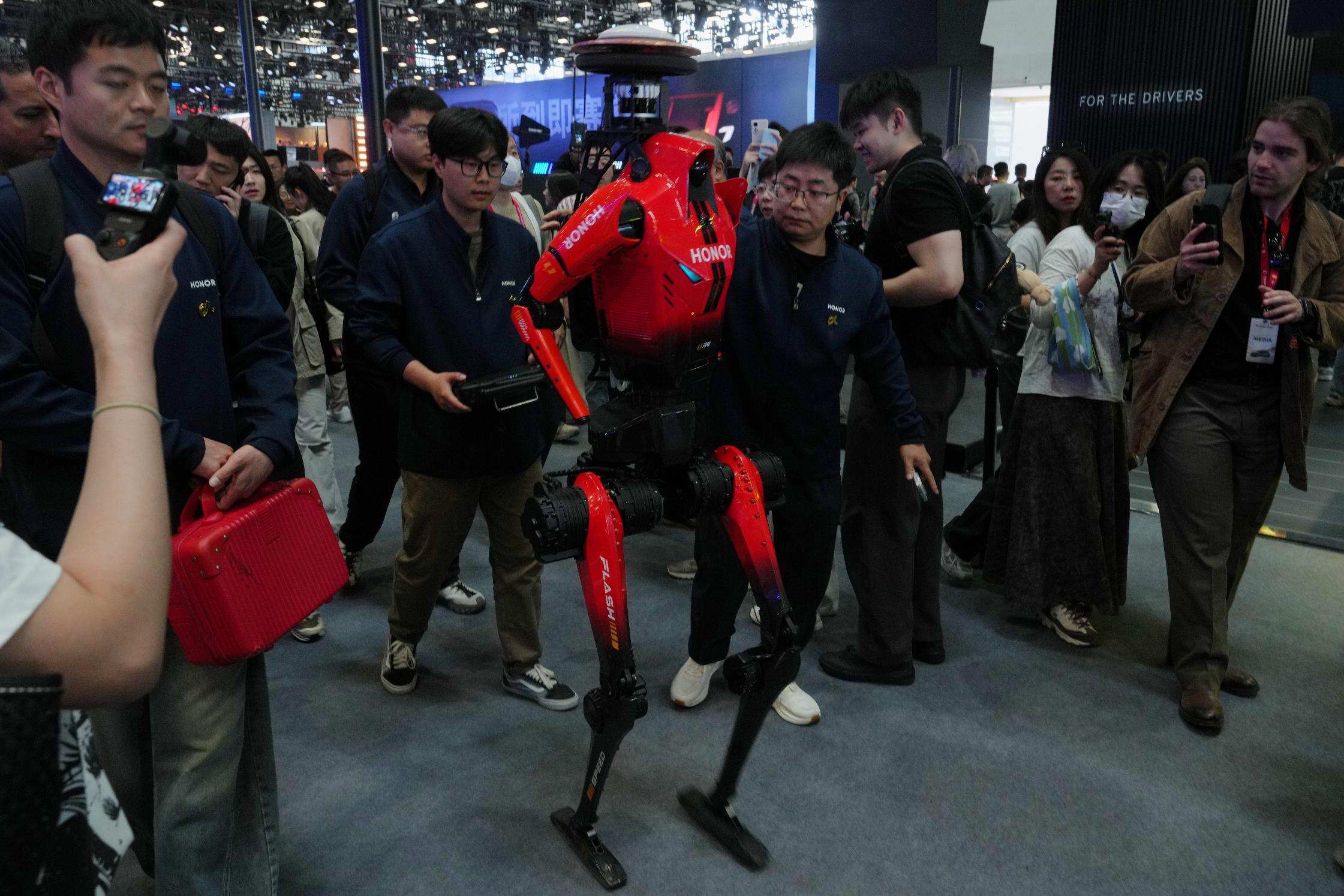 Honor, the humanoid robot which has won the humanoid robot half-marathon last weekend is surrounded by visitors as it visiting the Auto China 2026, in Beijing, Friday, April 24, 2026. (AP Photo/Andy Wong)
