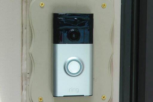 FILE - In this Friday, June 28, 2019, image made from video, a Ring doorbell camera is shown at a home in Coon Rapids, Minn.  From what you buy online, to how you remember tasks, to when you monitor your doorstep, Amazon is seemingly everywhere. And it appears the company doesn’t want to halt its reach anytime soon. In recent weeks, Amazon has said it will spend billions of dollars in two gigantic acquisitions that, if approved, will broaden its ever growing presence in the lives of consumers.  (AP Photo/Jeff Baenen, File)