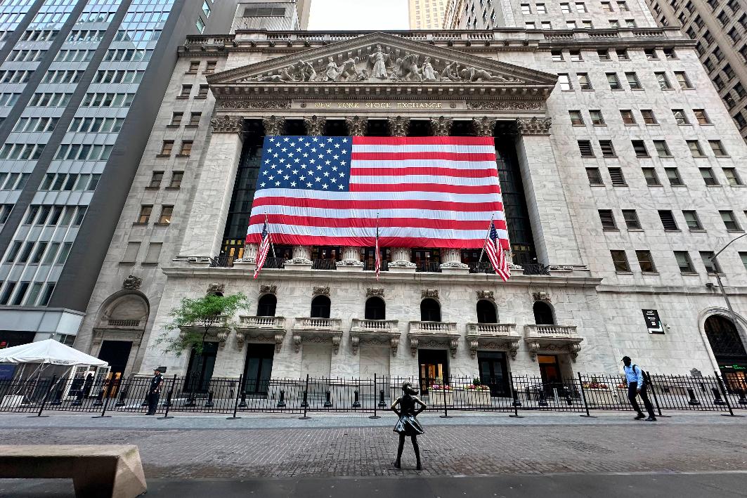 FILE - People pass the New York Stock Exchange on May 28, 2024, in New York. (AP Photo/Peter Morgan, File)