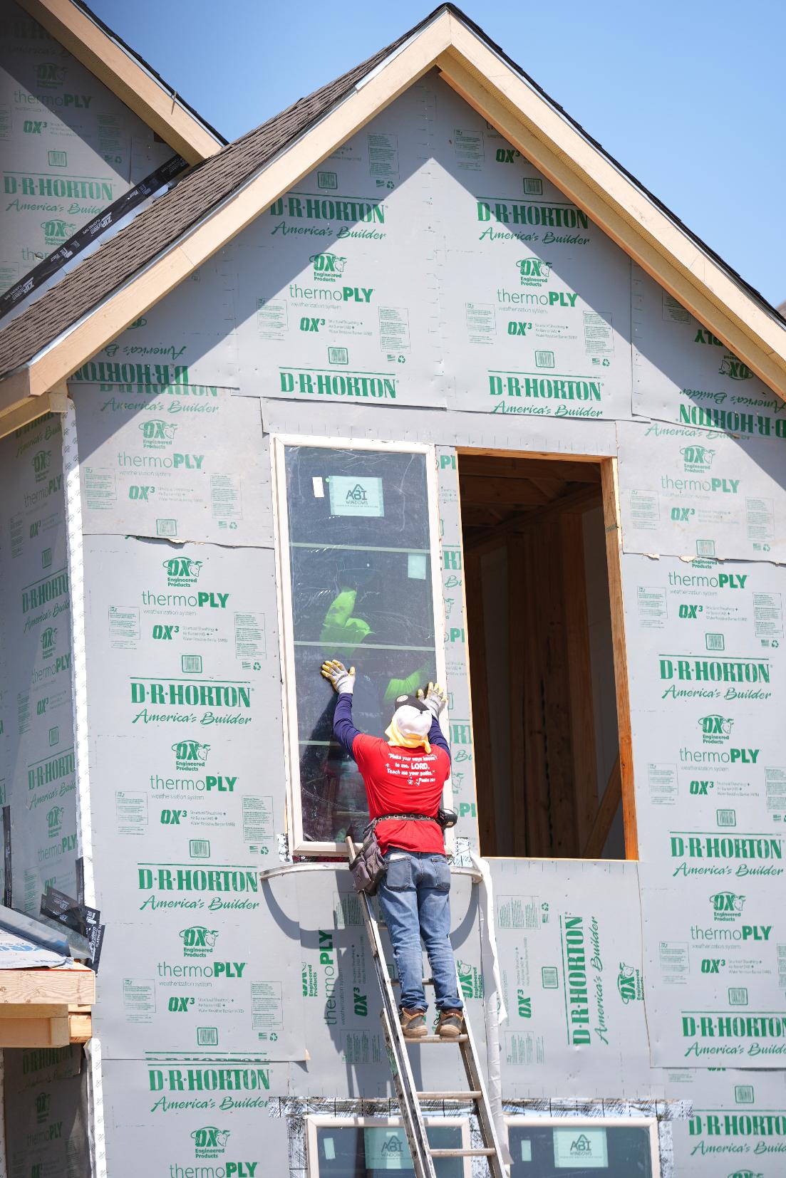 Workers install a window on a house under construction in Richardson, Texas, Monday, March 23, 2026. (AP Photo/LM Otero)