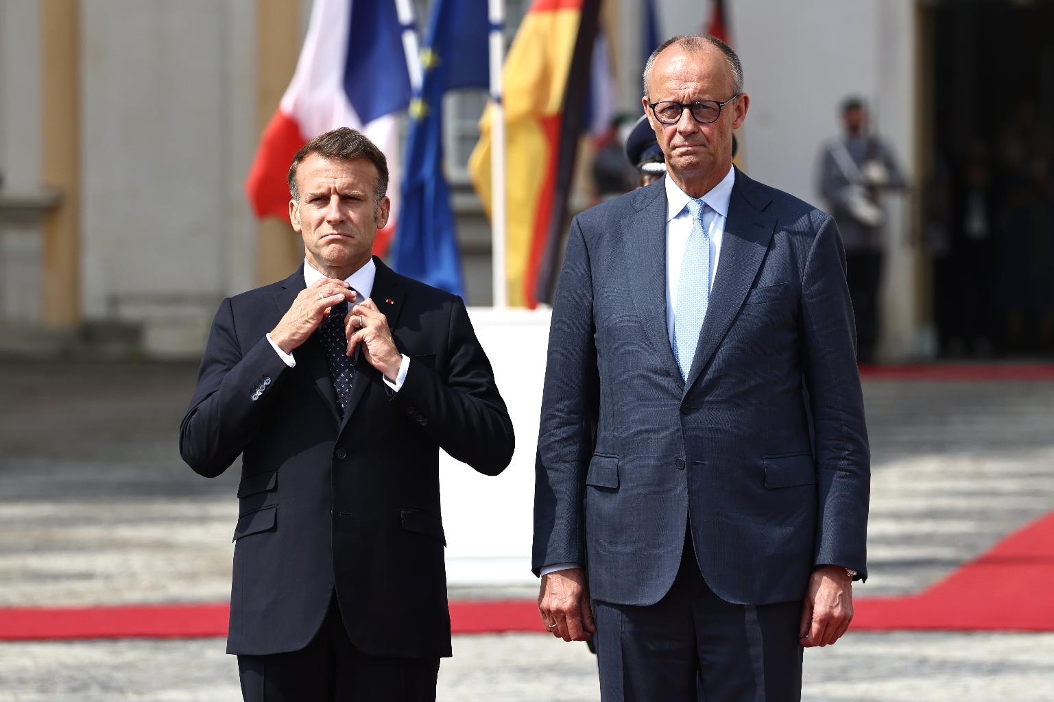 German Chancellor Friedrich Merz, right, welcomes French President Emmanuel Macron with military honors at Augustusburg Palace ahead of a meeting of the Franco-German Ministerial Council in Brühl, Germany, Friday, July 17, 2026. (Oliver Berg/dpa via AP)