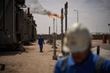 FILE - Workers walk in an area at a degassing station in Zubair oil field, whose operations have being reduced due to the Mideast war triggered by the U.S. and Israeli attacks on Iran, near Basra, Iraq, March 28, 2026. (AP Photo/Leo Correa, File)