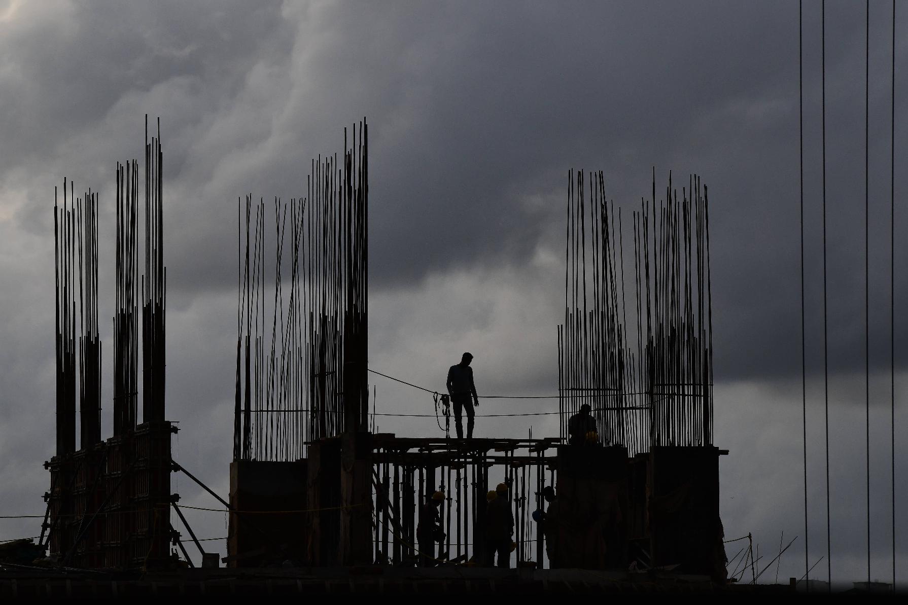 Workers at a construction site are silhouetted against the evening sky filled with pre-monsoon rain clouds in Kochi, southern Kerala state, India, Tuesday, June 2, 2026. (AP Photo/ R S Iyer)