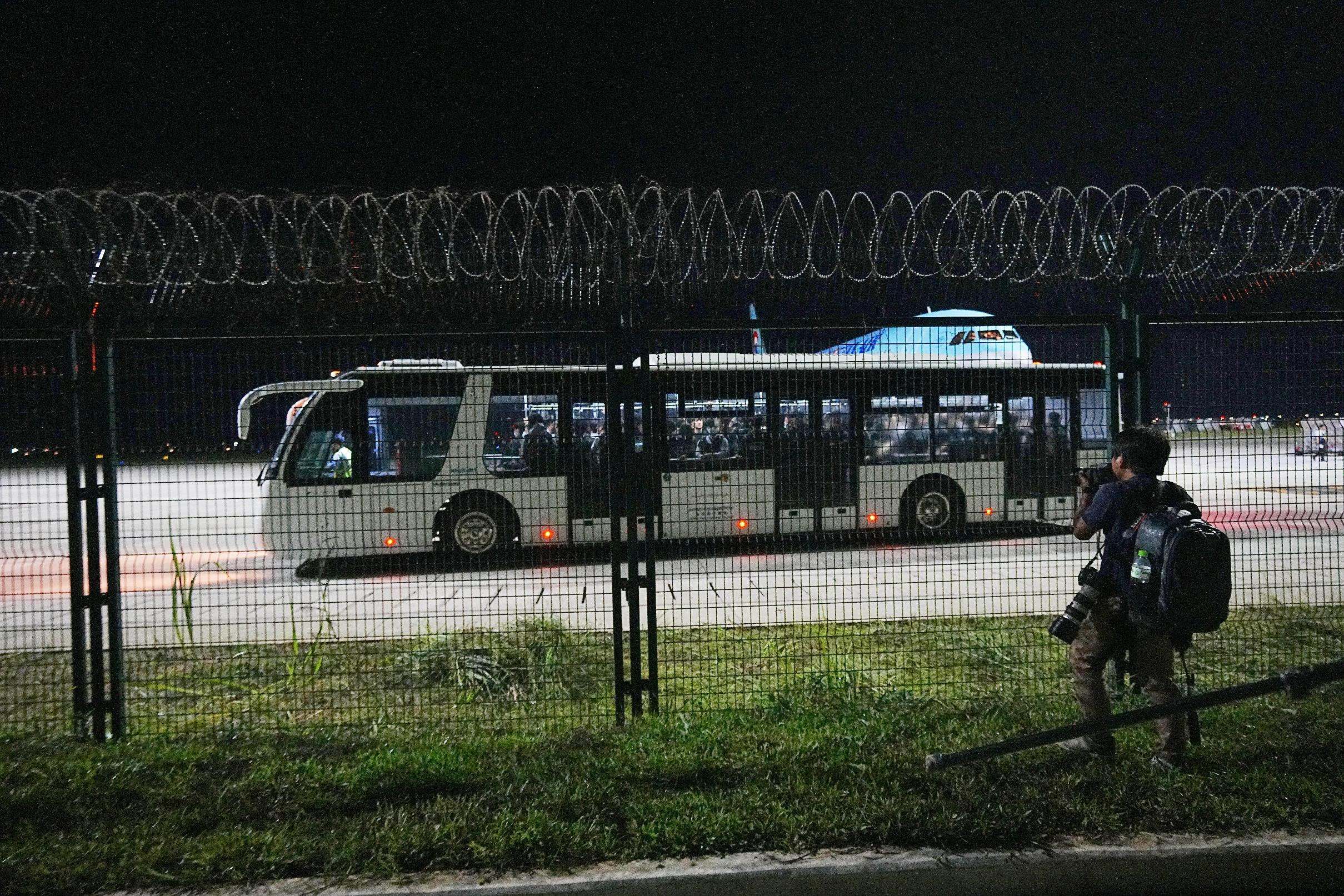 Korean Air staff and police officers ride a bus at Techo International Airport in Kandal province, Cambodia, Friday, Oct. 17, 2025. (AP Photo/Heng Sinith)