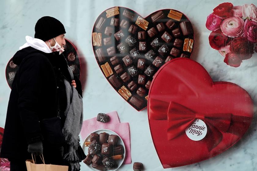 FILE - A man passes a Fannie May chocolate shop in downtown Chicago on Valentine's Day, Feb. 14, 2021. (AP Photo/Nam Y. Huh, File)